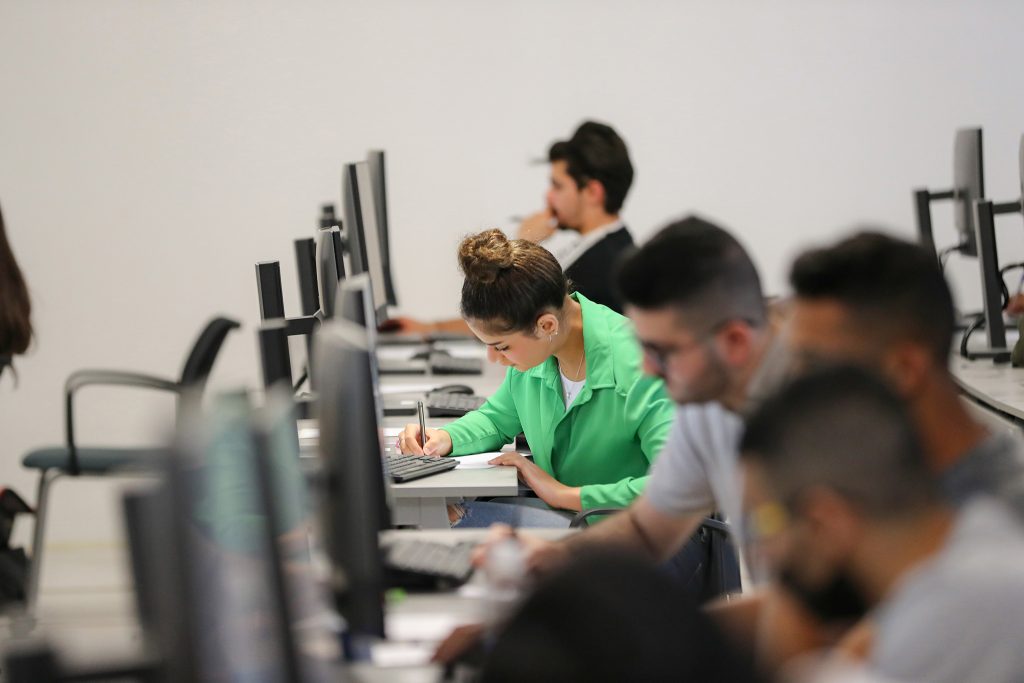 Students attending a class within the College of Business at AUIB.