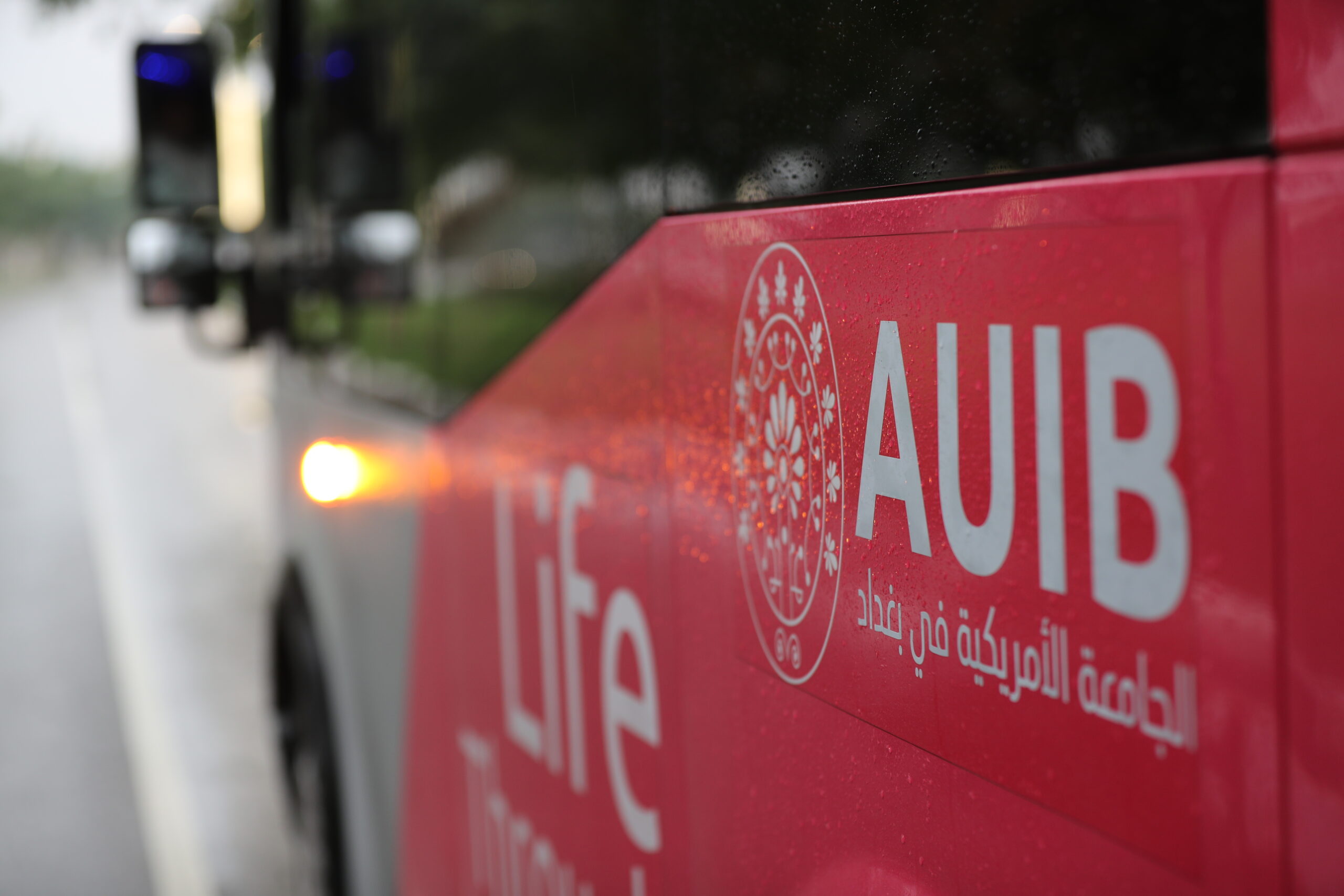 Picture of the side of a AUIB campus shuttle bus.